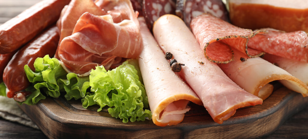Wooden Board With Assortment Of Delicious Deli Meats On Wooden B
