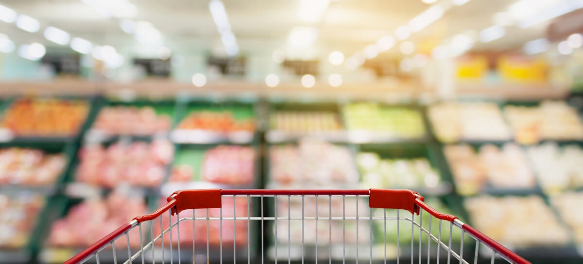 Shopping Cart With Fruits And Vegetables On Shelves In Supermark